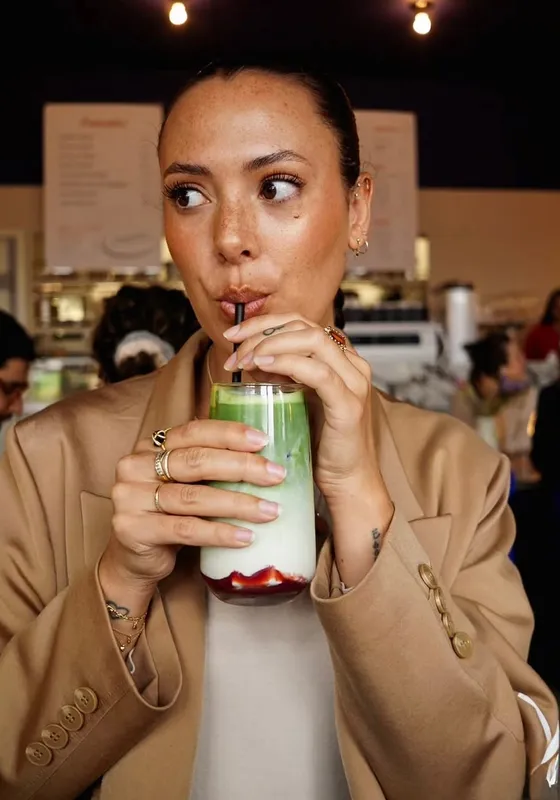 Guest holding a glass of cold drink with a red sleeve