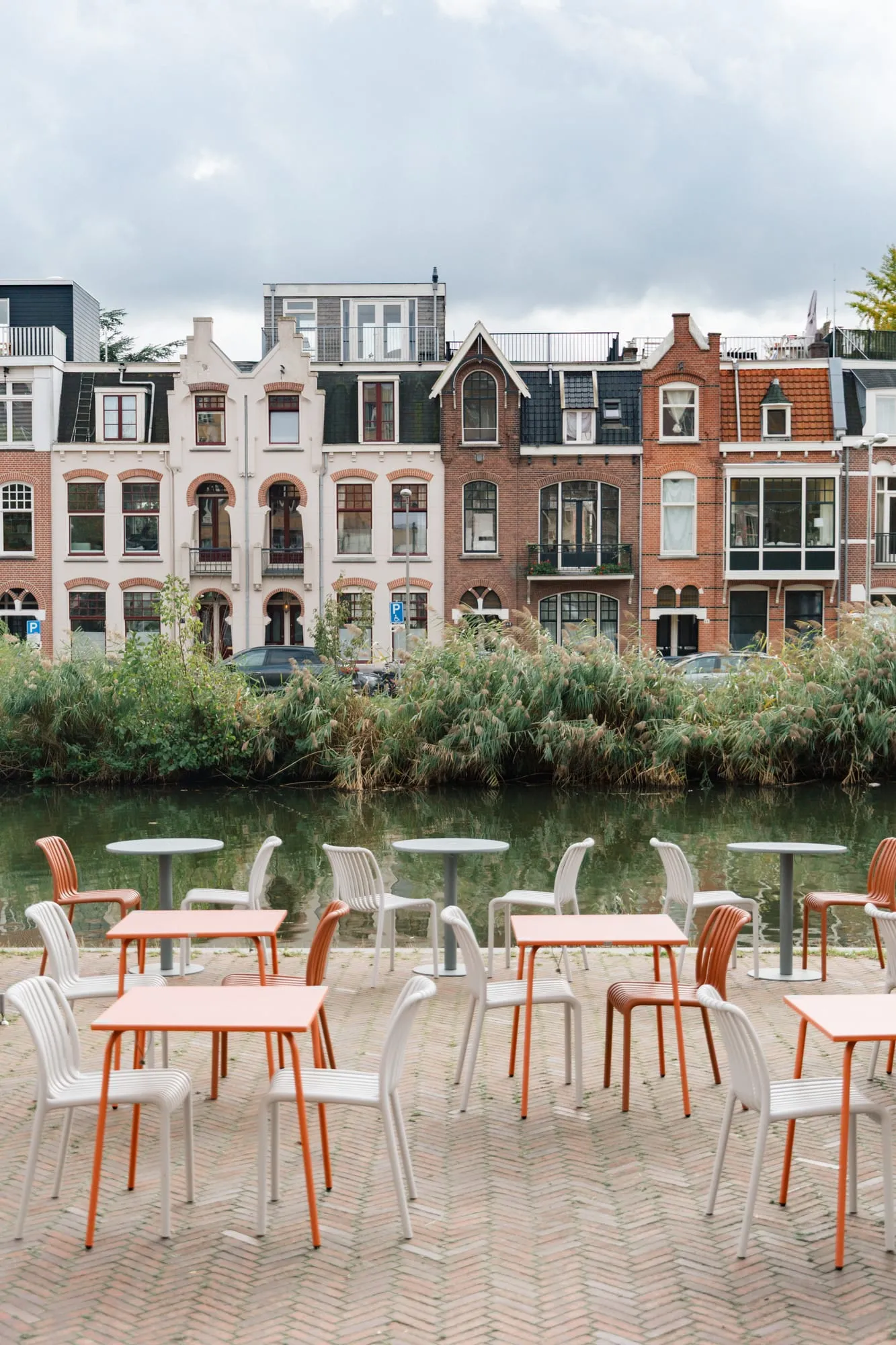 The BQ Canteen terrace by the water, with pink tables and chairs